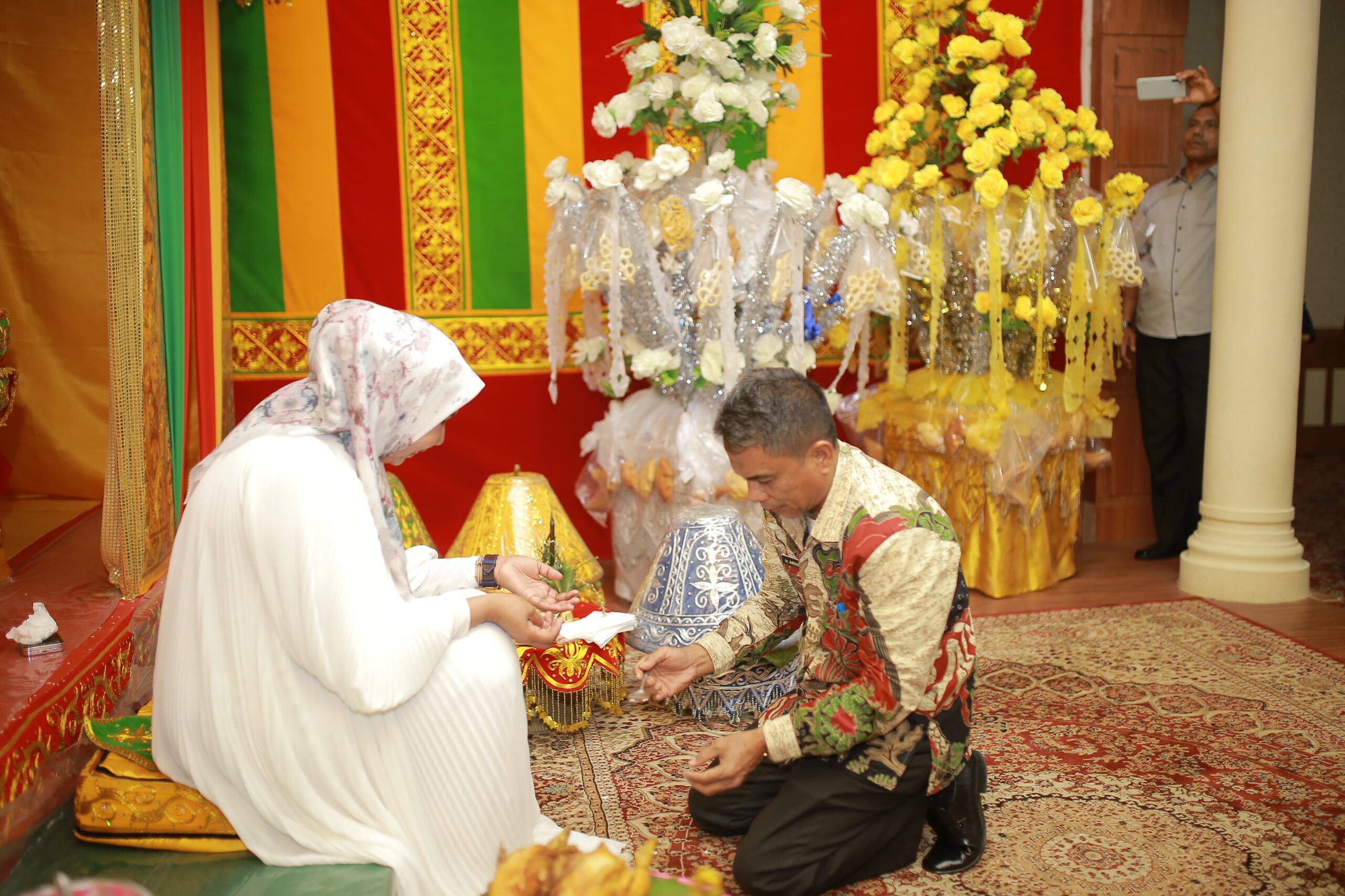 Seorang pria berlutut di atas permadani di Desa Peusijuek Pj Bupati Nagan Raya, sepulang dari perjalanan umroh.
