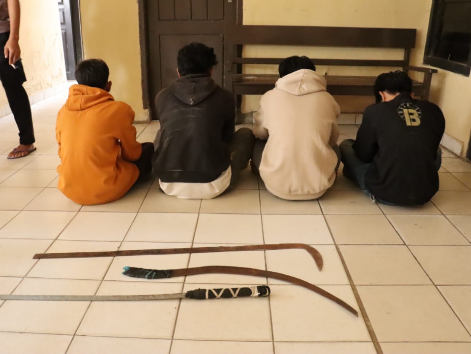 Sekelompok remaja duduk di lantai sambil memegang pisau.