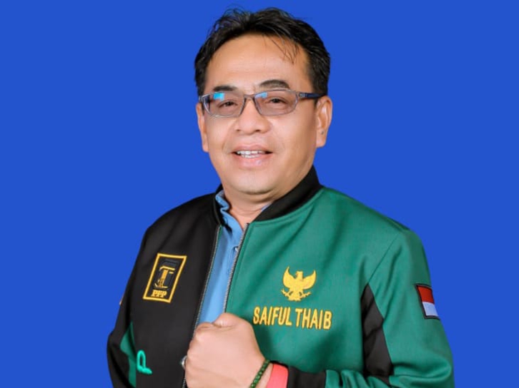 Seorang pria Terpilih berjaket hijau berpose untuk difoto.