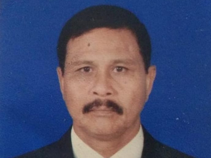 Seorang pria berjas dan berdasi serta berkumis sedang melakukan siaran wartawan di Aceh Selatan.